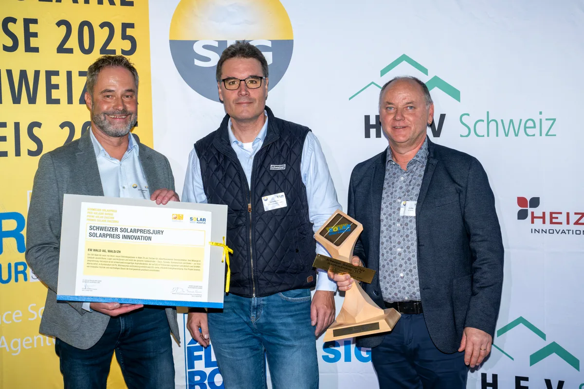 Drei Männer mit einer Urkunde und einem Pokal für den Solarpreis 2025.