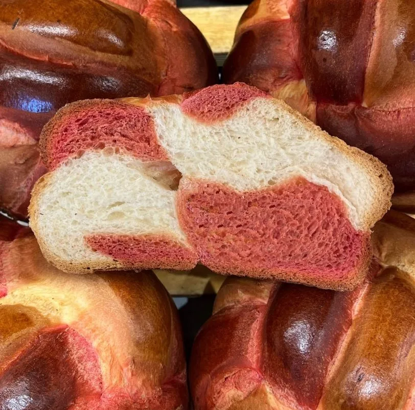 Ein Hefezopf, dessen Tei rot und weiss ist.