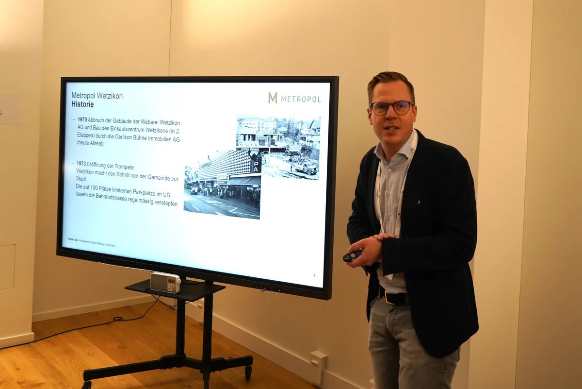 Besichtigung des Neubaus Metropol durch das Wirtschaftsforum Wetzikon. Robin Althaus erklärt die Entstehungsgeschichte. Er steht vor einem Bildschirm.