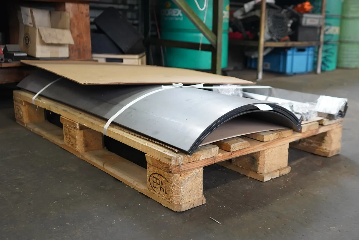 Auf einer Europalette liegen Teile aus Stahlblech, aus denen ein Pflug gefertigt werden kann.