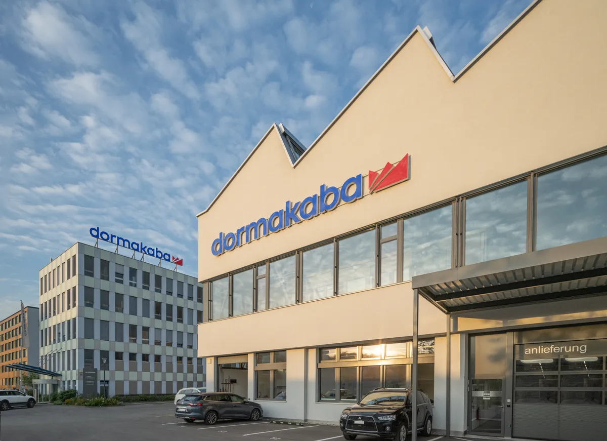 Aussenansicht des Hauptsitzes der Dormakaba International Holding AG. Ein zweistöckiges Industriegebäude.