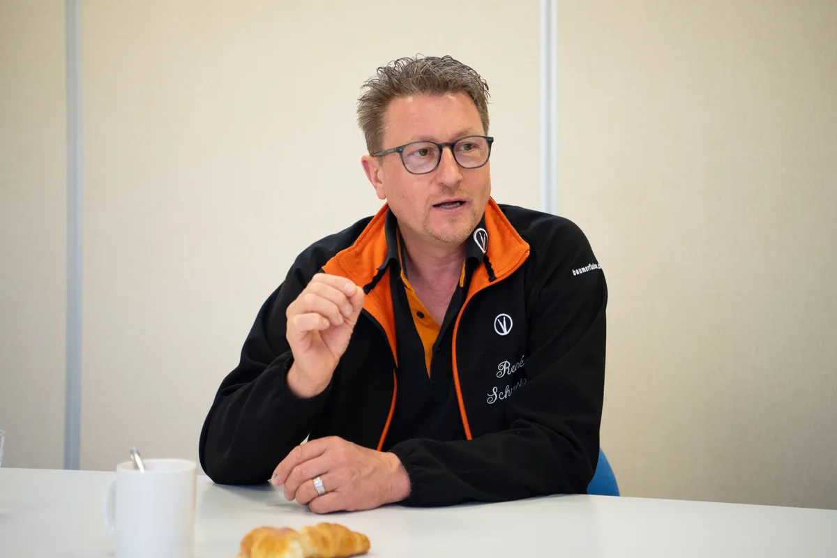 Mann gestikuliert während eines Interviews.