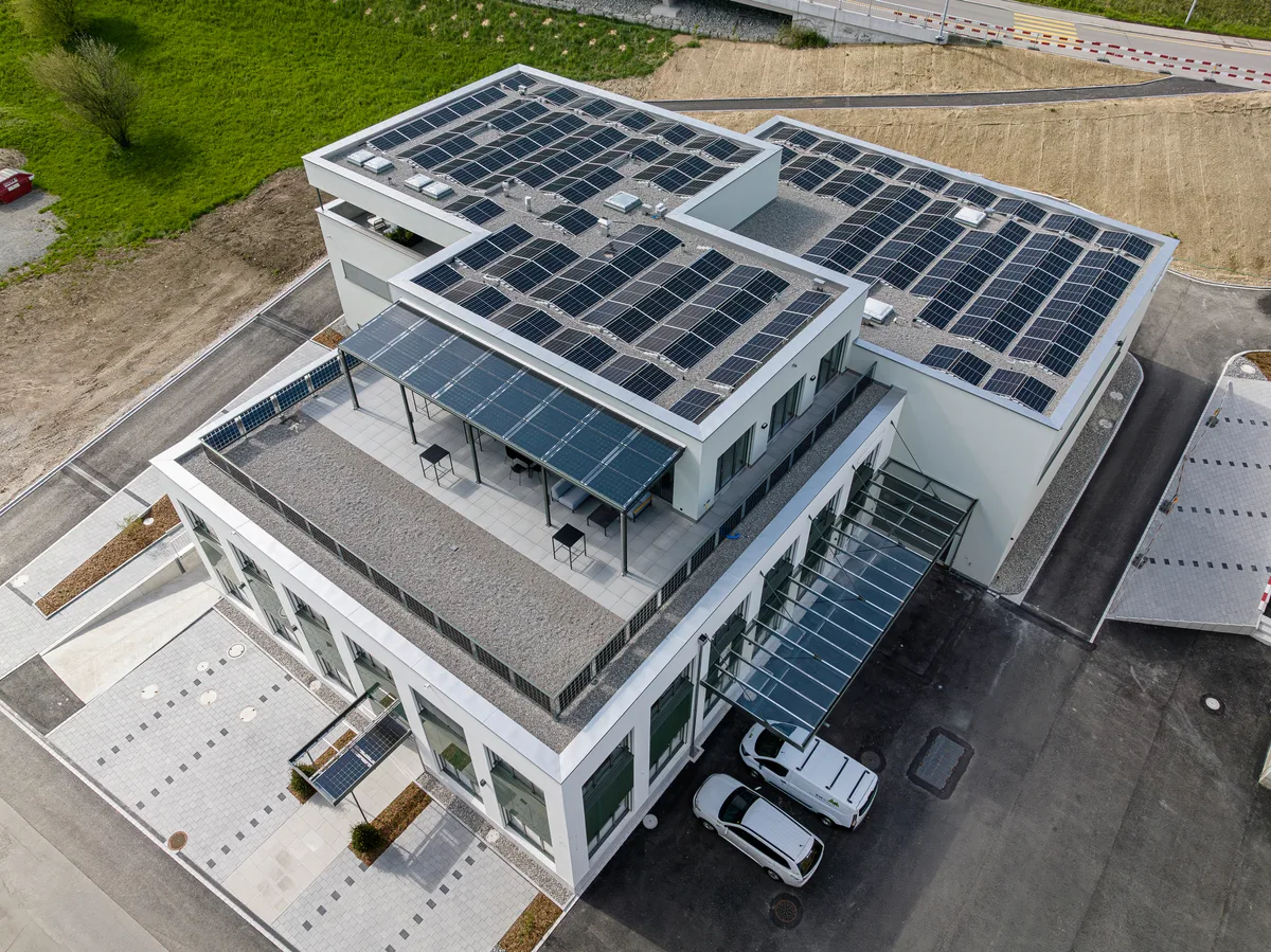 Aussenansicht der Betriebsgebäudes der EW Wald AG. Ein modernes, dreistöckiges Bürogebäude mit Solarpanels auf dem Dach und an der Fassade.