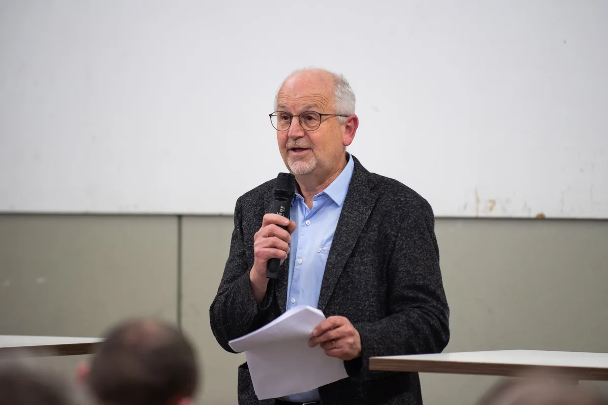 Ein Herr im Sakko an einem Mikrofon.