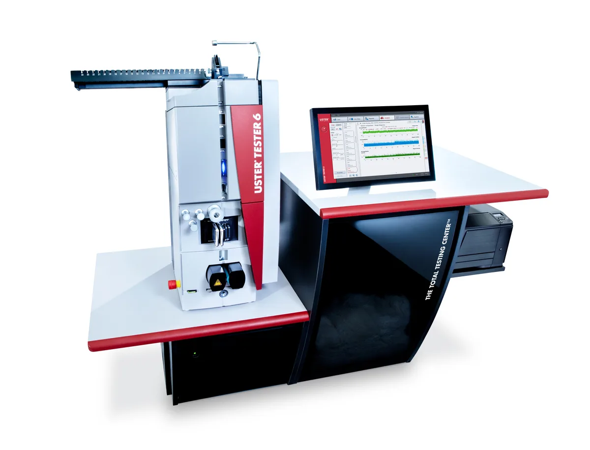 Hightech aus Uster: Der Uster Tester 6 wird in Spinnereien eingesetzt, um die Gleichmässigkeit von Garnen zu prüfen. Der Uster Tester 6 bestehend aus einem schwarzen Sockel, einem Bildschirm und einem turmartigen Aufbau, durch den das Garn läuft.