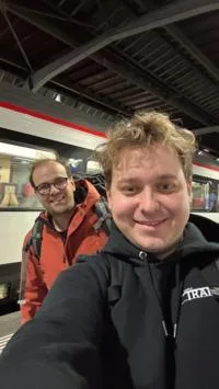 Trotz missglücktem Weltrekordversuch blicken die Mitarbeiter von Simple Train positiv in die Zukunft. Zwei Männer blicken in die Kamera, im Hintergrund ist ein Zug zu sehen.