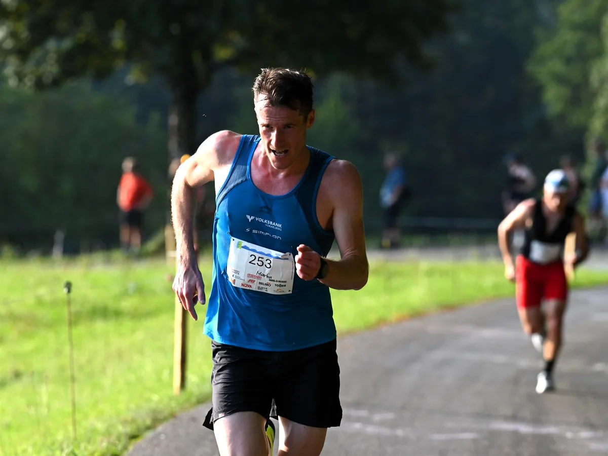 Zwei Läufer sind zu sehen, einer im Vordergrund und gross, einer unscharf im Hintergrund.