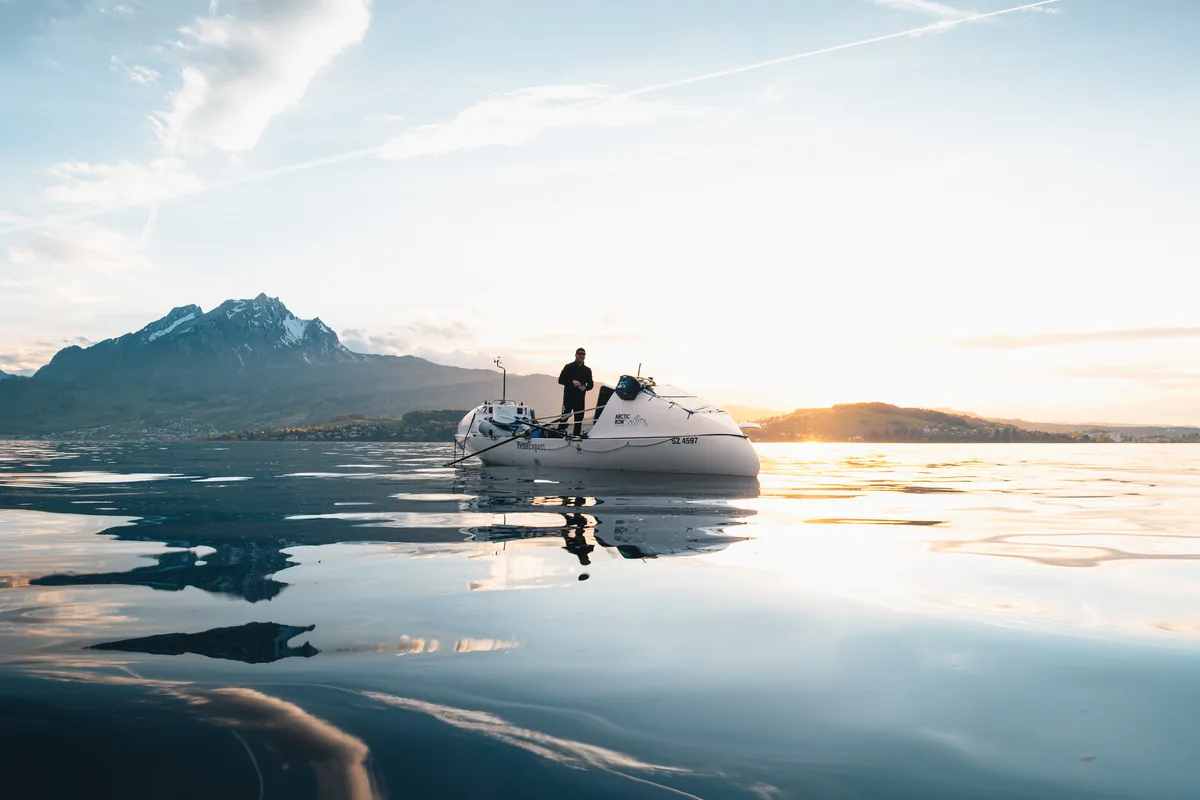 Ein Mann steht auf einem speziell aussehenden Boot.