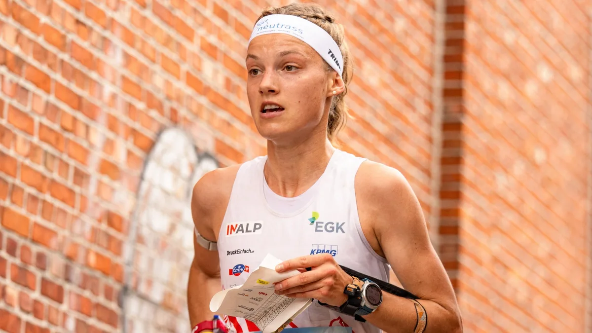 Simona Aebersold führt vor dem Final den Gesamtweltcup an. Eine OL-Läuferin vor einer Backsteinwand.