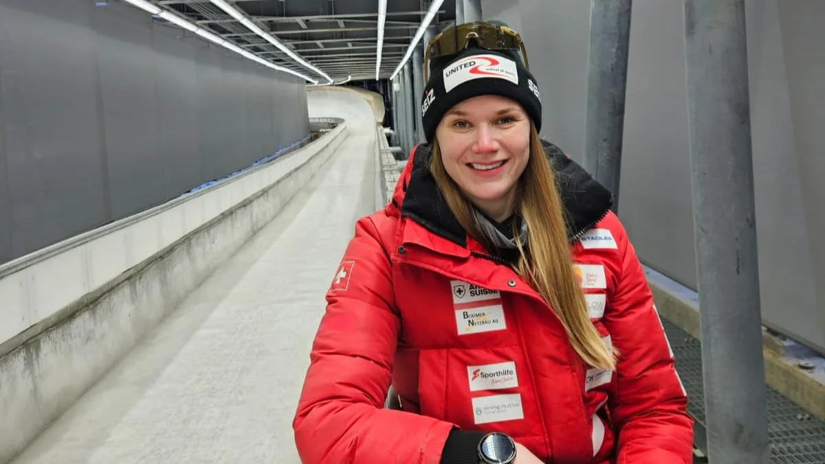 Eine Frau mit Wintermütze an einer Bobbahn.