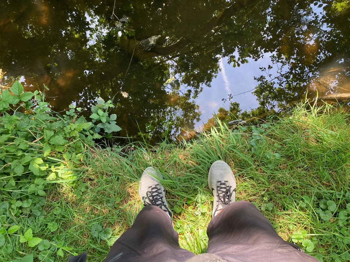 Wasser spielt auf der Illnauer Feierabendrunde eine wichtige Rolle. Zwei Füsse in Turnschuhen am Wasser.