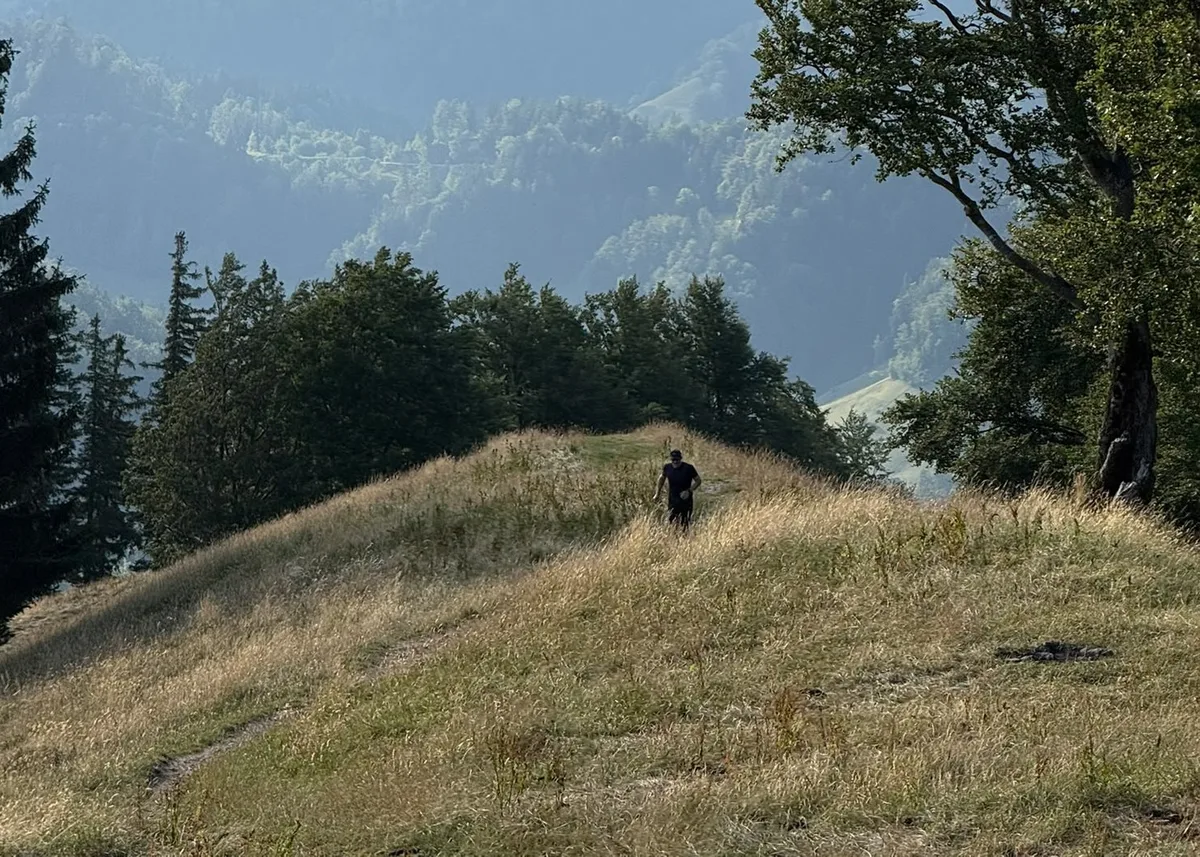 Ein Mann auf einer steilen Wiese.