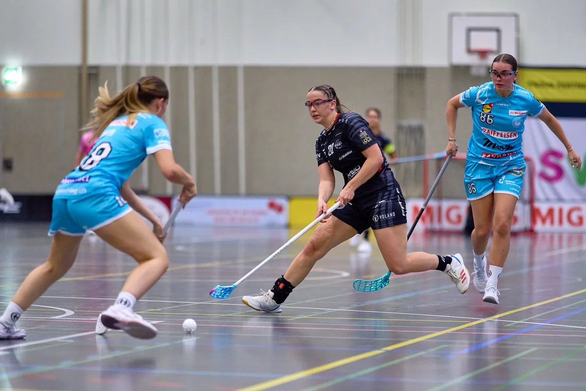 28679043-3 Riders-Spielerin Kate Meldere zwischen zwei Churerinnen.