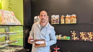 12948085-11 Christian Deppeler Janz mit zwei kleieren Stücken vom Oberländer Nussfladen. Am Dorffest will der Wilemer den grössten Fladen der Welt produzieren.
