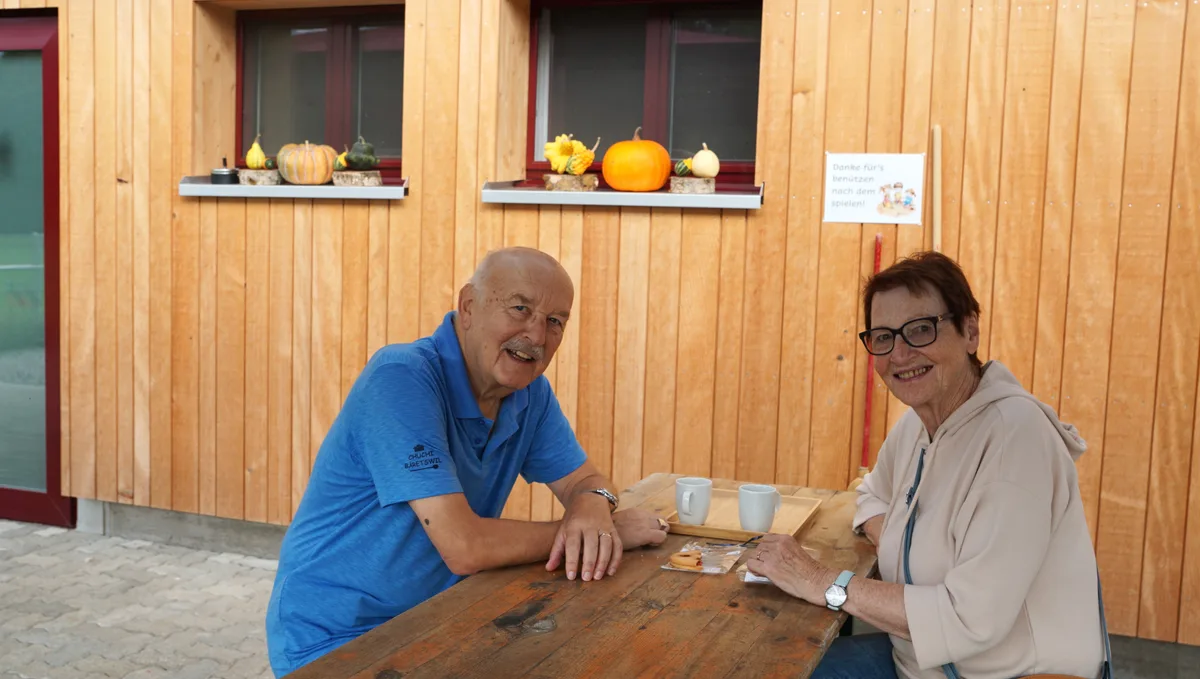 Ein Mann und eine Frau sitzen im Aussenbereich des Cafés.