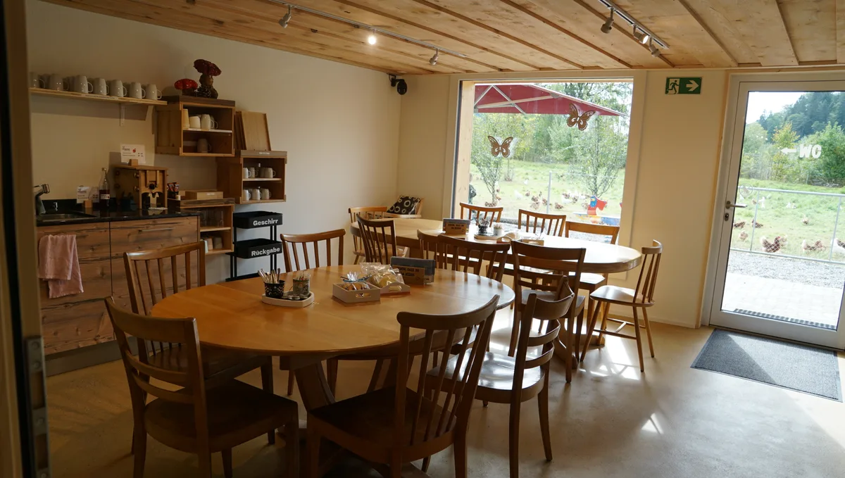 Man sieht den Innenraum des Cafés mit runden Holztischen.