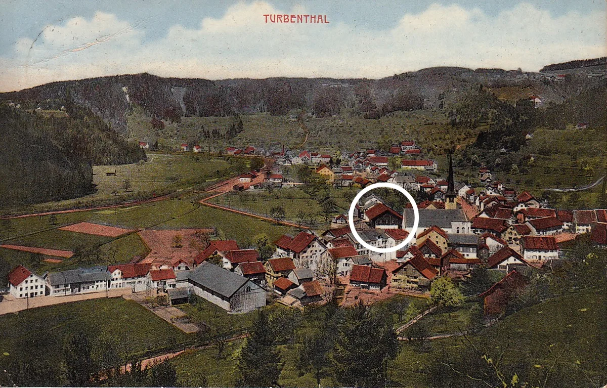Auf dieser kolorierten Postkarte von zirka 1900 kann man das Ökonomiegebäude neben der Kirche erkennen. Man sieht eine kolorierte Postkarte, auf der ein Gebäude eingezeichnet ist.