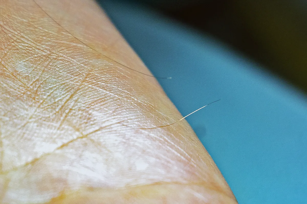 Dieser ist sogar dünner als ein menschliches Haar. Haar und Draht im Vergleich in der Manufaktur HiFiction in Turbenthal.