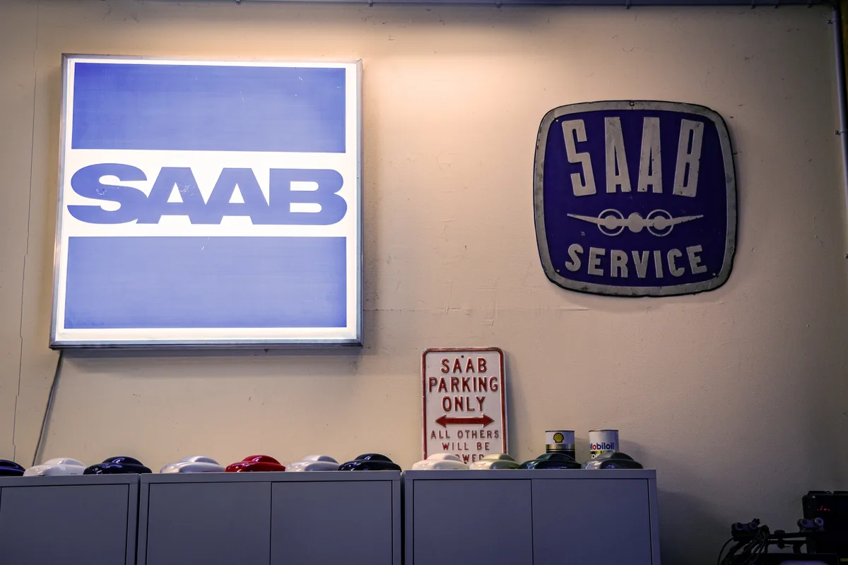 Zwei Embleme der Automarke Saab hängen an der Wand.