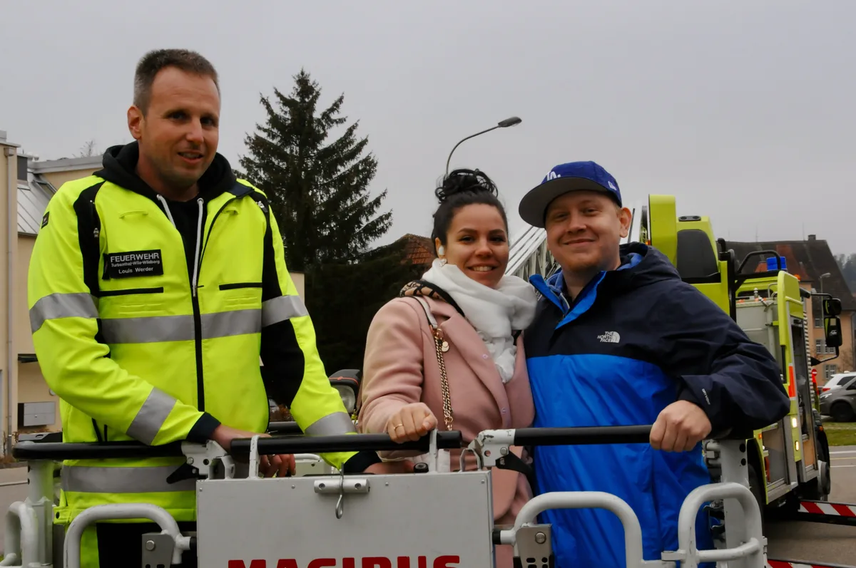 Man sieht drei Menschen auf der Drehleiter.