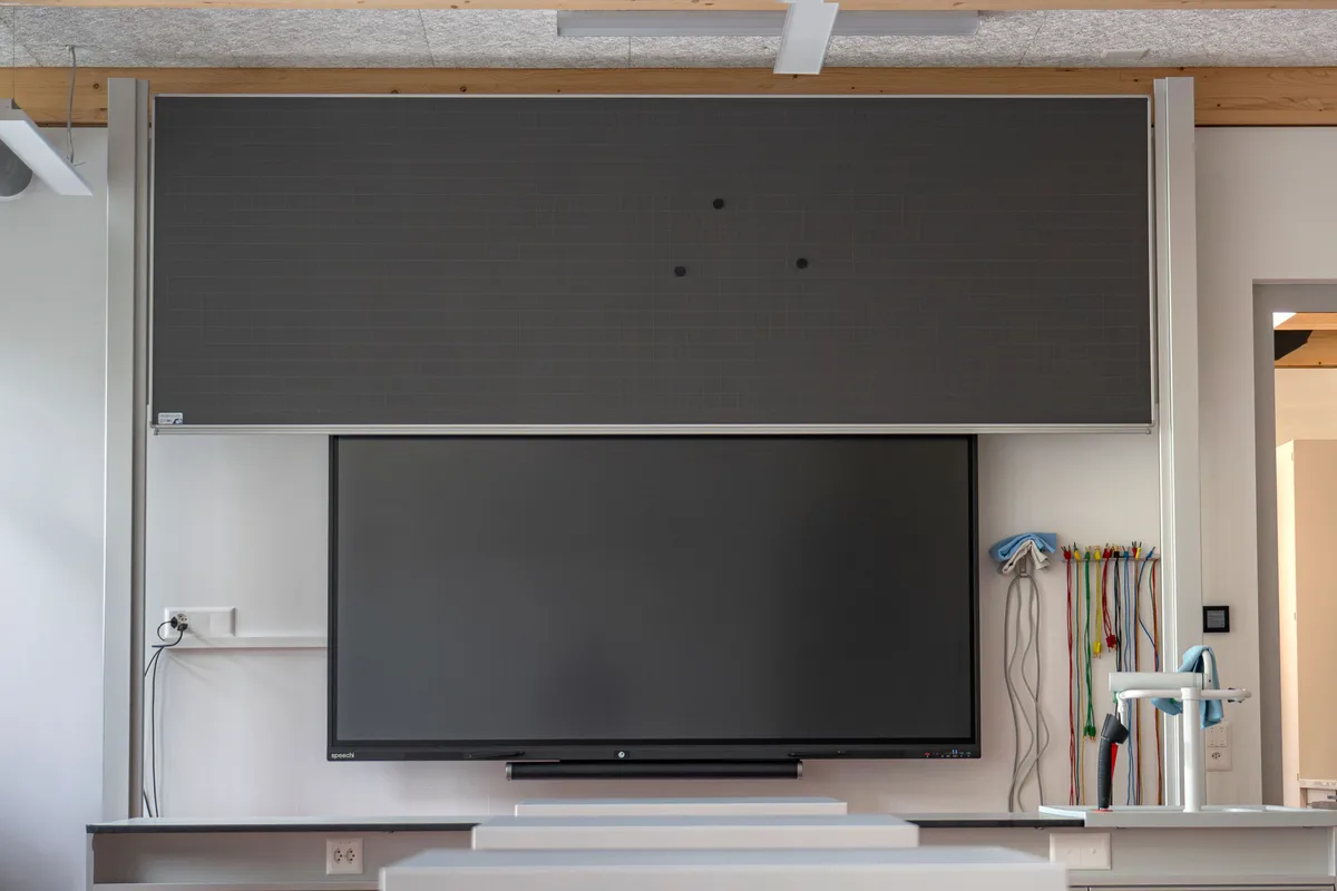 In allen Schulzimmern hängt neuerdings ein Whiteboard-Display mit Touchscreen, das zum Beispiel für das Zeigen von Inhalten oder für Gruppenaufträge genutzt werden kann. Das sind die neuen Leinwände mit einem standardgemässen Display.