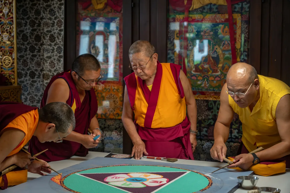 Man sieht buddhistische Mönche miteinander diskutieren.