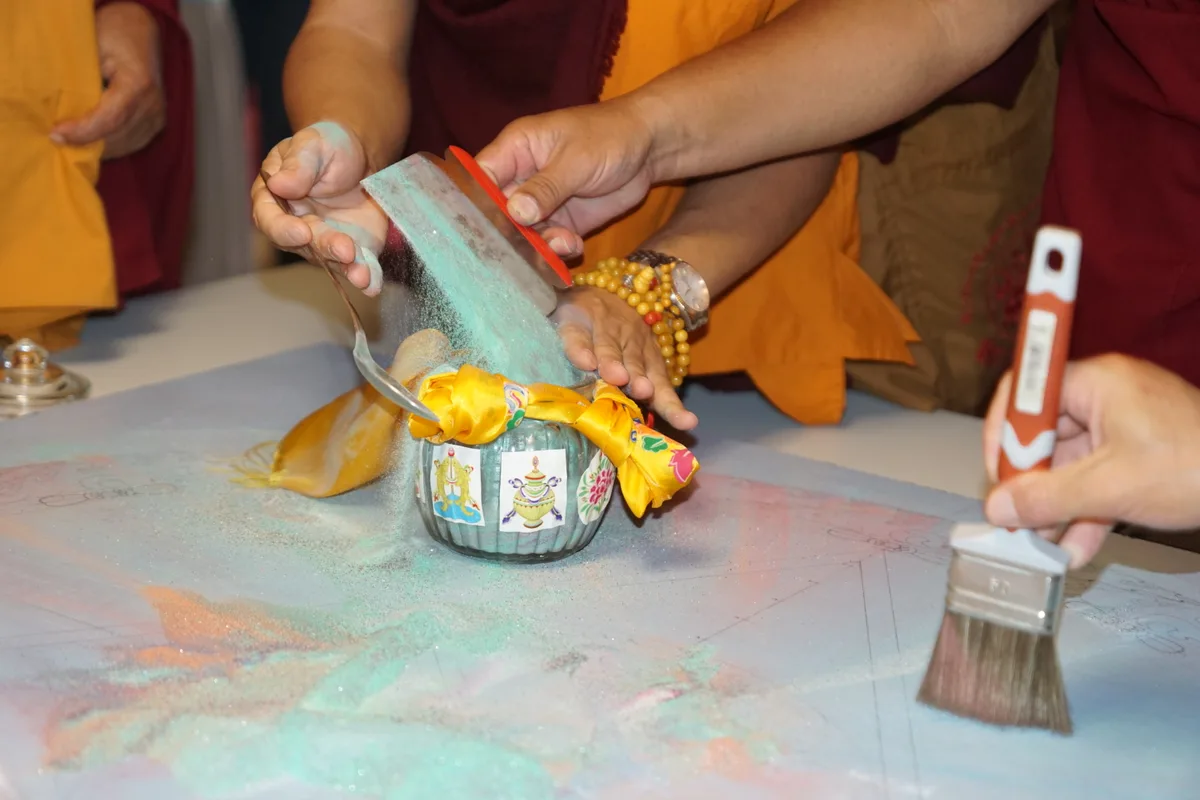 Fast der gesamte Sand des Mandalas ist in einem Glasgefäss.