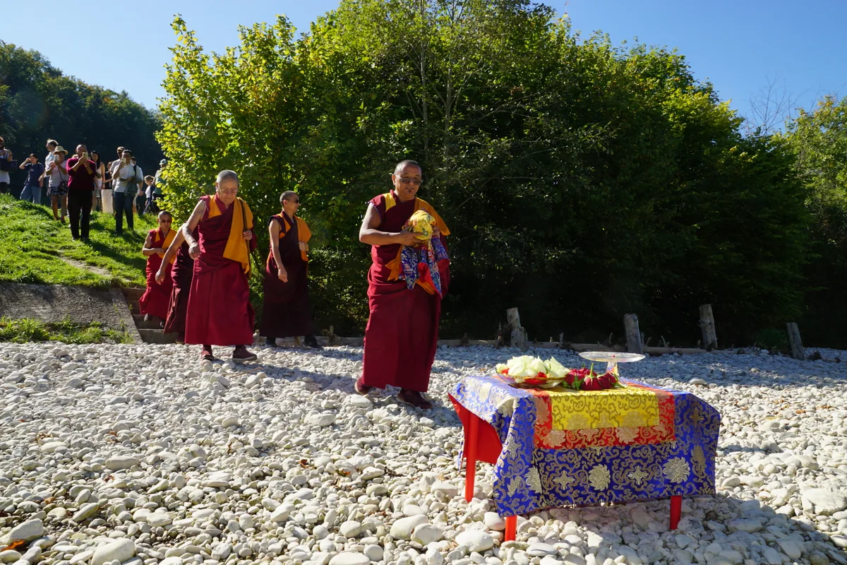 Man sieht die buddhistischen Mönche, wie sie die Treppe zur Töss heruntersteigen.
