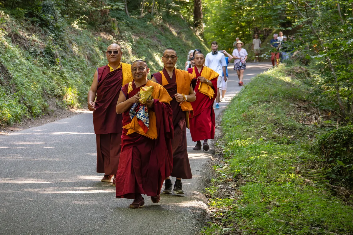 Die Mönche und die Besuchergruppe auf dem Weg durch den Wald … Man sieht Besucher einer Gruppe von Mönchen durch den Wald folgen.