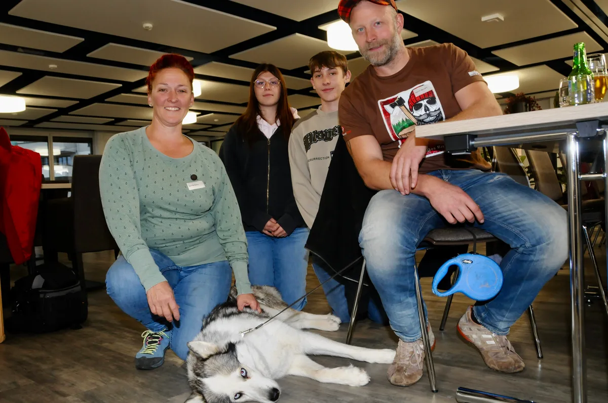 Man sieht eine Familie mit Hund.