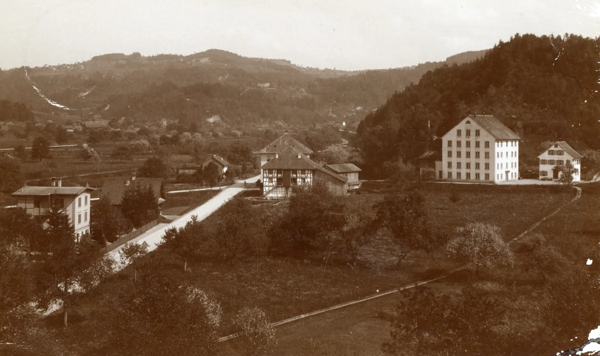 Die Aufnahme von etwa 1900 zeigt rechts das markante Fabrikgebäude mit der darin seit 1873 untergebrachten Paul Hotz Teigwarenfabrik A.G. Wila. Ein altes Foto eines Fabrikgebäudes.