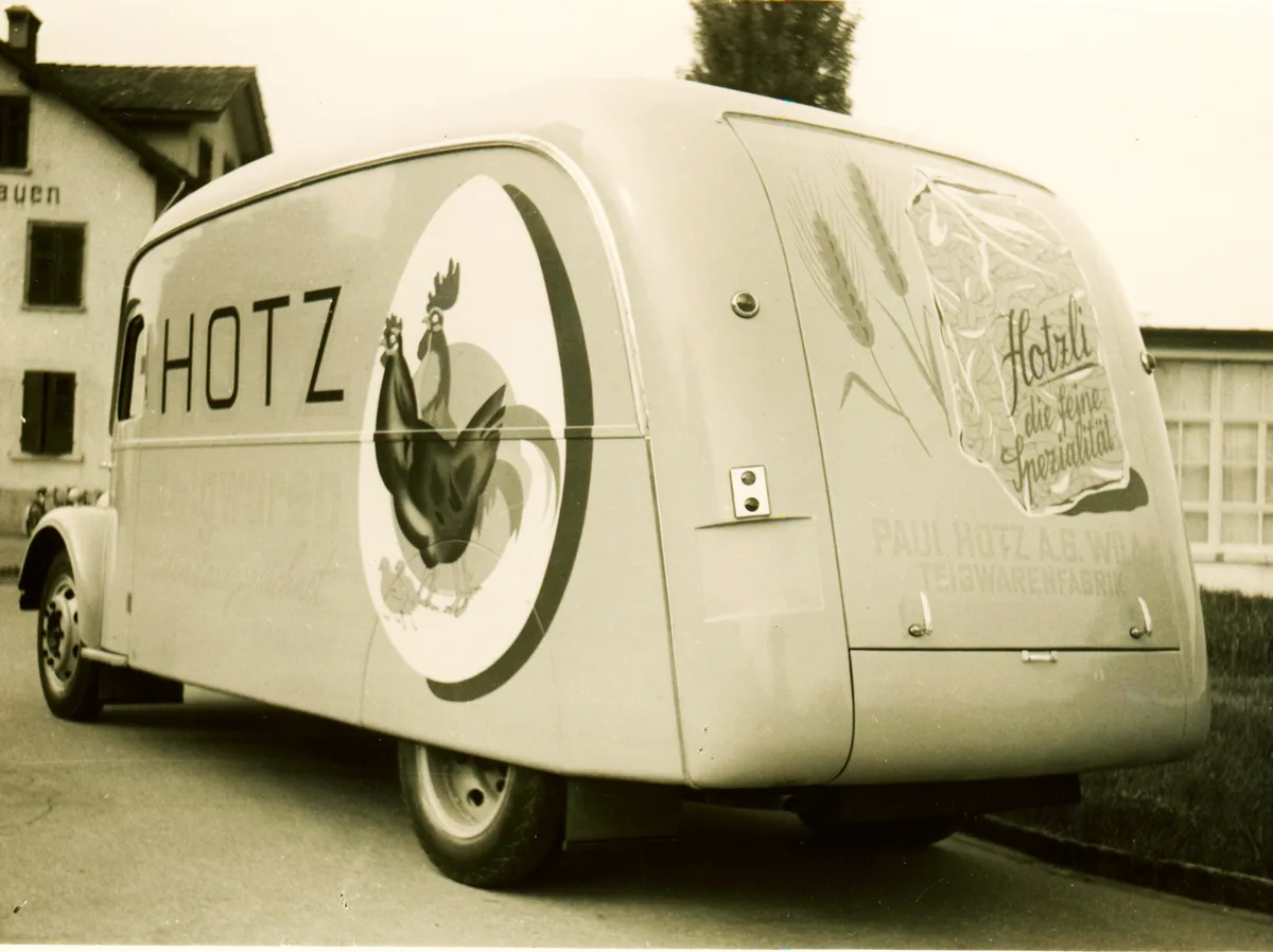 Das optische Erkennungszeichen der Hotz-Nudel waren das Huhn und der Güggel. Man sieht ein altes Fahrzeug mit Gügglen drauf.