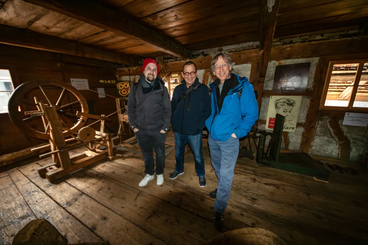 Man sieht drei Männer in einem alten Haus.