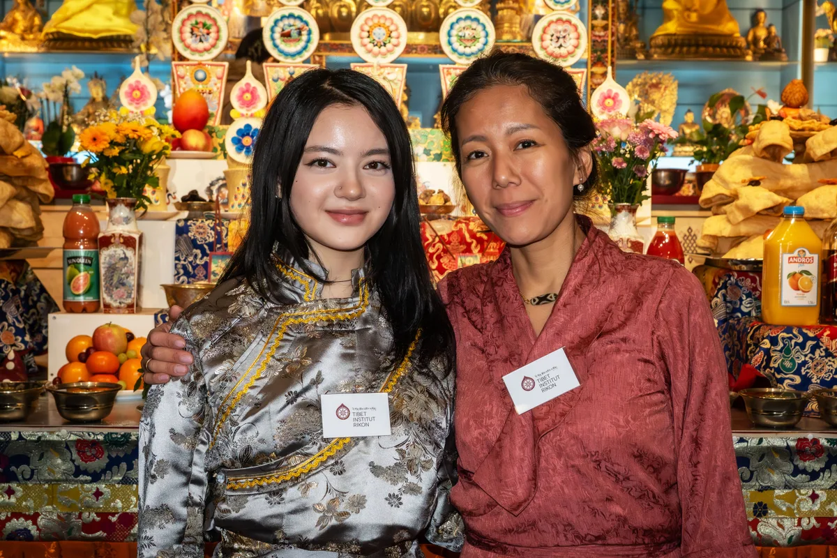 Man sieht zwei Tibeterinnen vor einem Altar.