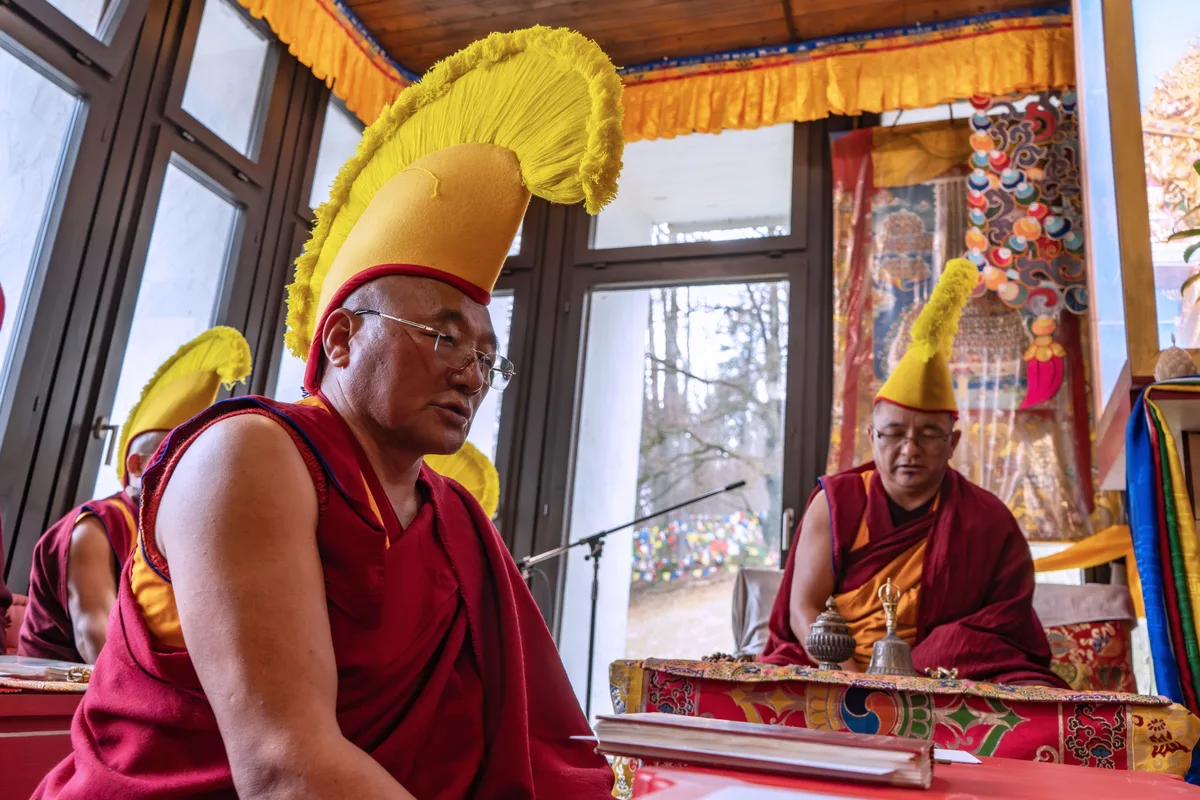 Man sieht Mönche, die beten und meditieren.
