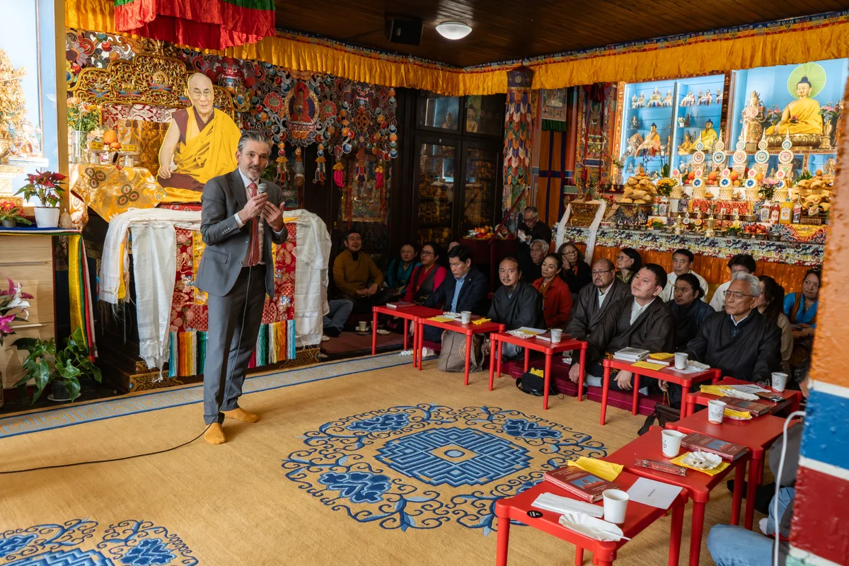 Man sieht Zeremoniebesucher in einem tibetischen Gebetsraum.