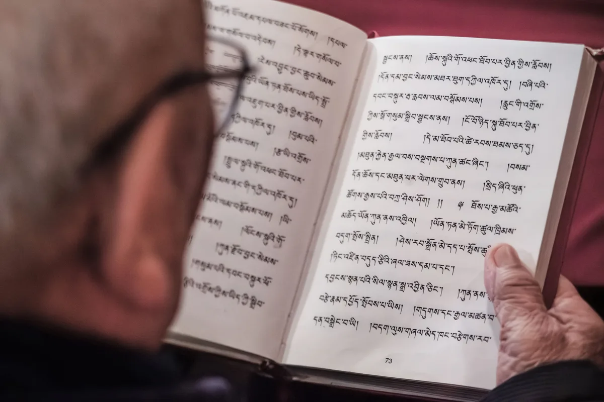 Man sieht ein Buch, das in tibetischer Schrift geschrieben ist.