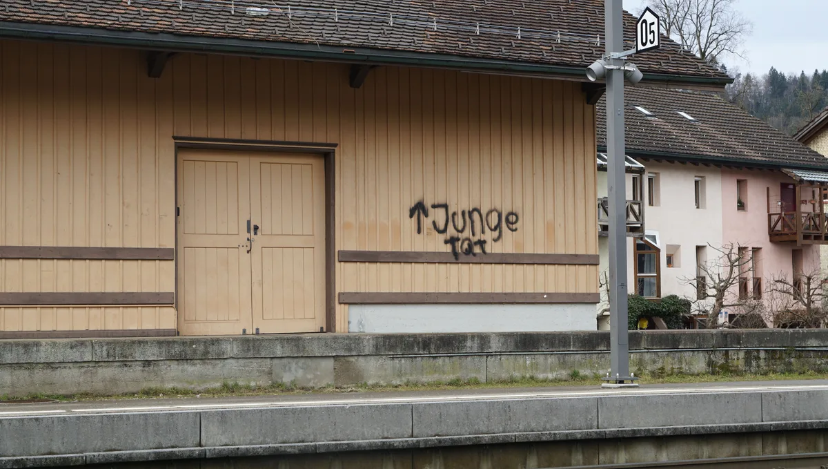 Man sieht Sprayereien an einem Bahnhof.