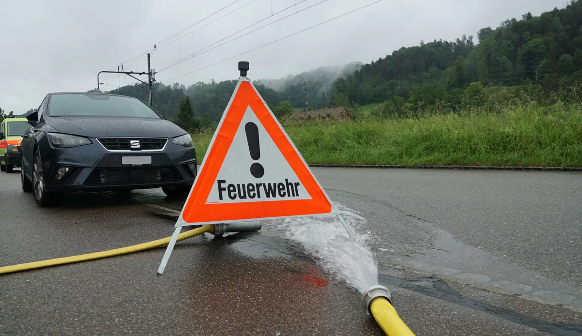 Warndreieck mit Wasserschlauch.