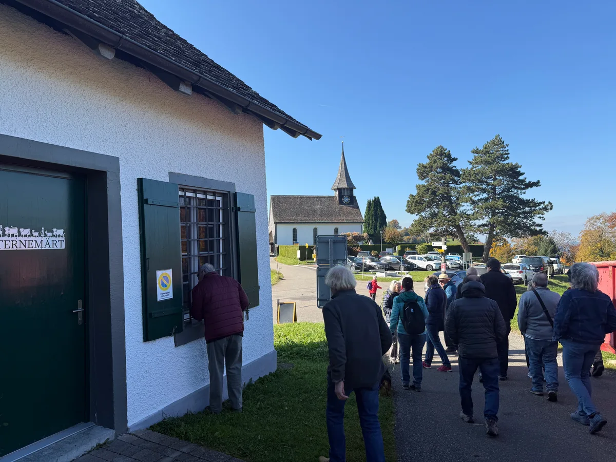 Man sieht Menschen unterwegs in einem Dorf.