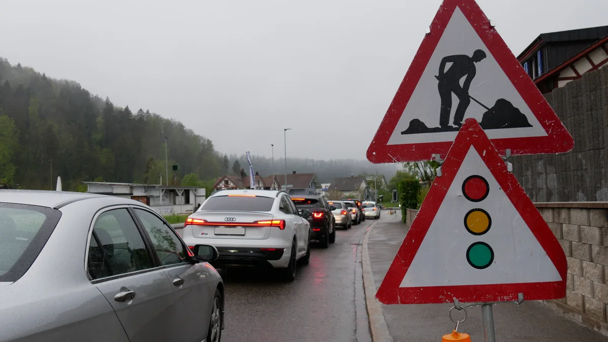 Man sieht Autos, die sich vor einer Baustelle stauen.