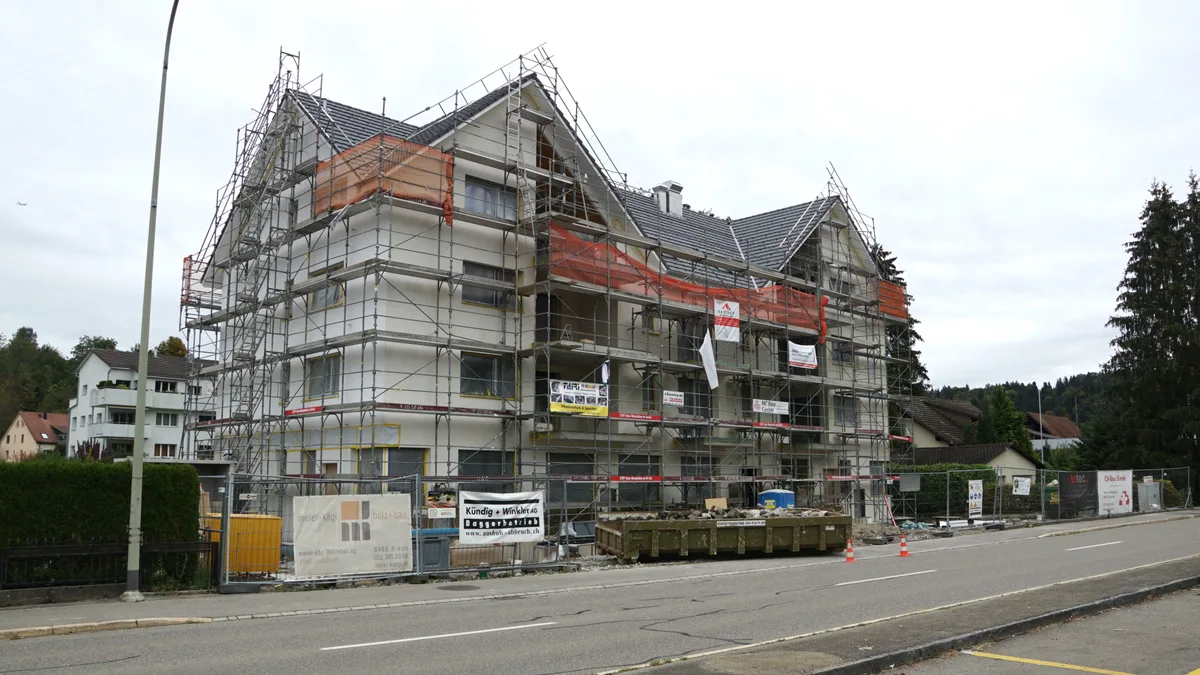 Man sieht eine Wohnüberbauung mit Baugerüsten.