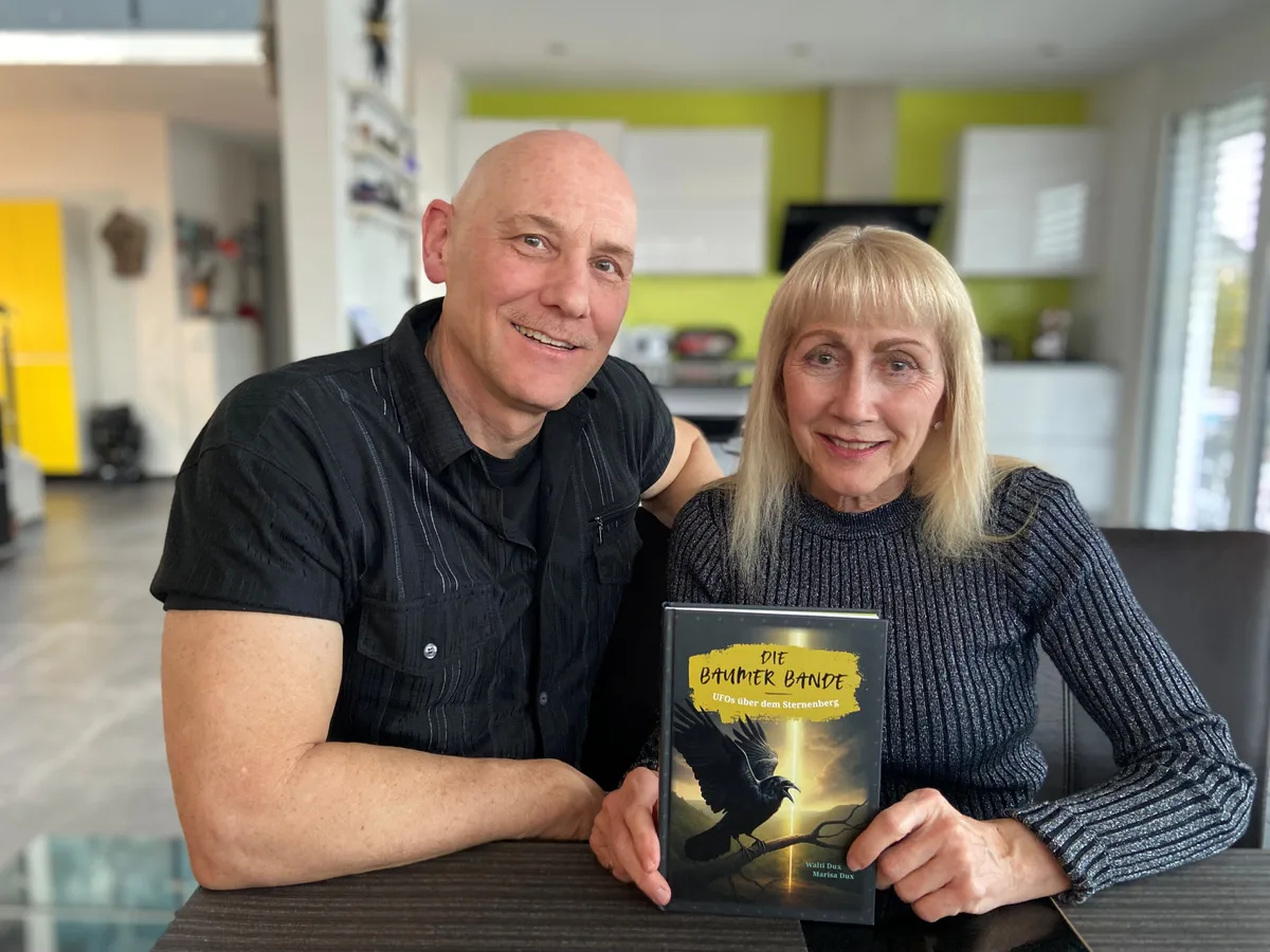 Marisa und Walti Dux sitzen in ihrer Küche und halten ihr neuestes Buch in den Händen.