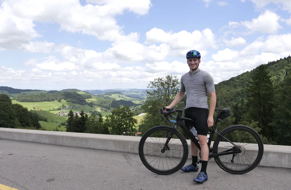 Porträt eines jungen Mannes mit Rennvelo.