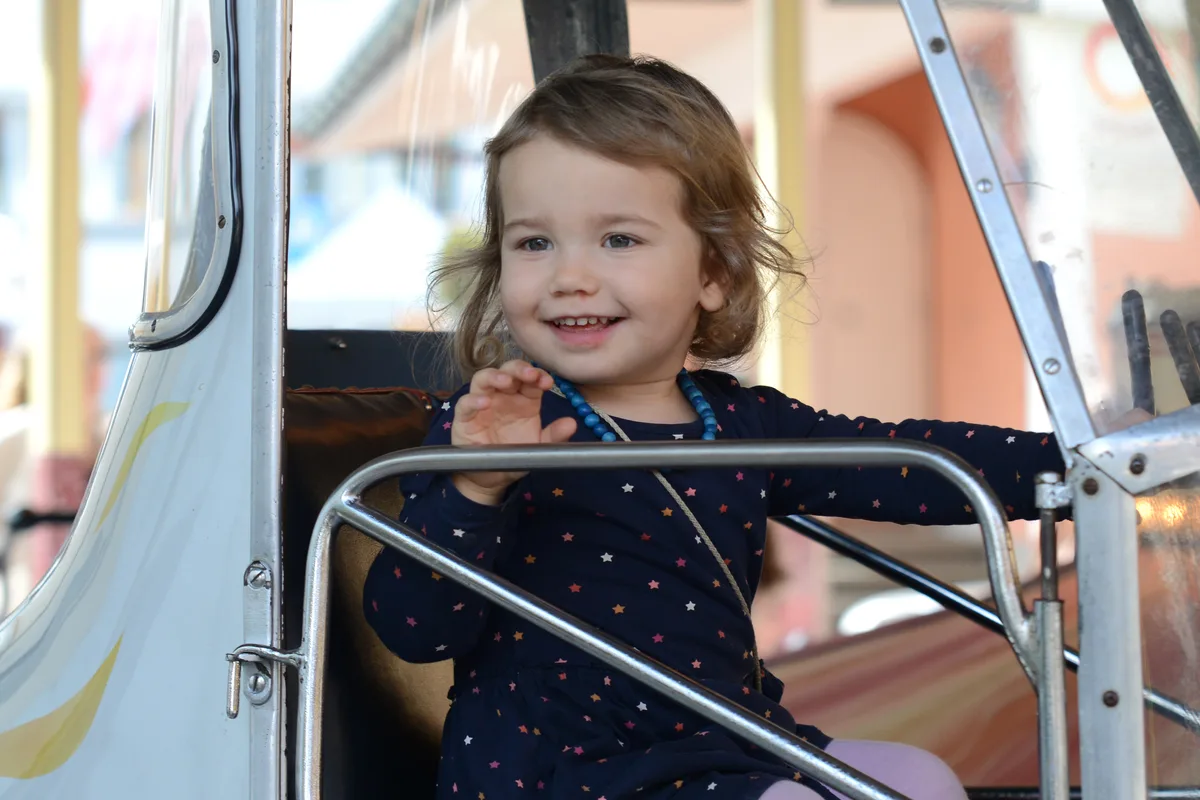 Mädchen lächelt vom Karussel.