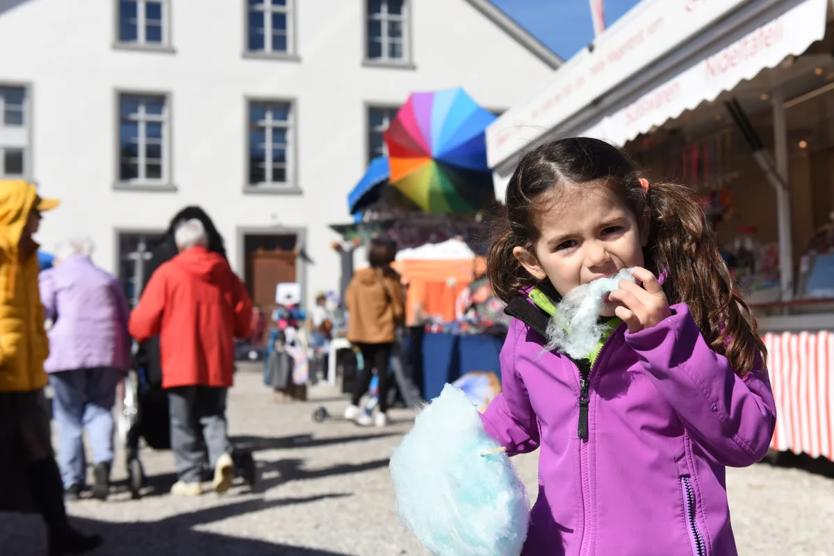 Zuckerwatte in allen Farben. Mädchen genoss es Zuckerwatte in allen Farben. Mädchen genoss es