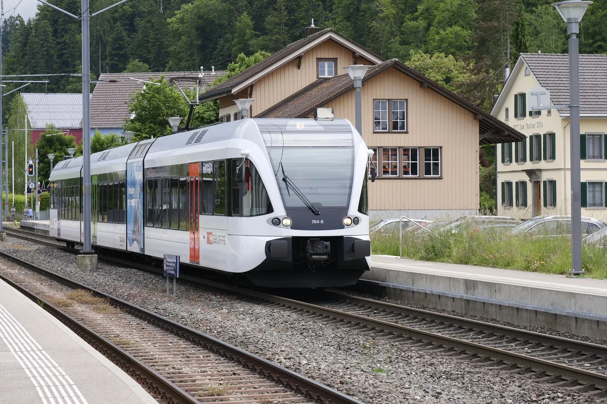 Man sieht einen Zug, der gerade von einem Gleis losfährt.