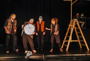24779825-3 «Die vier Brüder» mit Masken, im Hintergrund der musikalische Leiter Kilian Deissler.