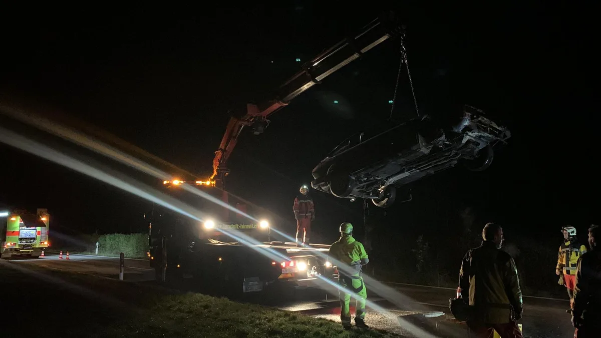 Man sieht ein Auto, das mit einem Kran gehoben wird.