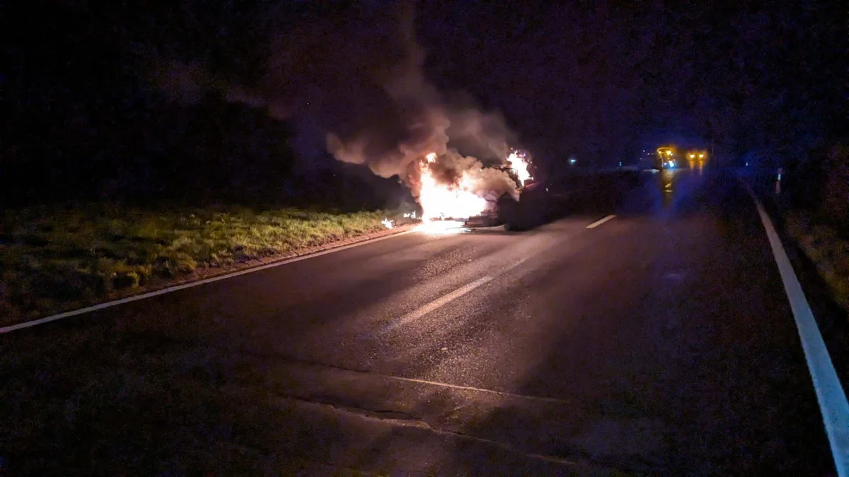 Man sieht ein brennendes Auto.